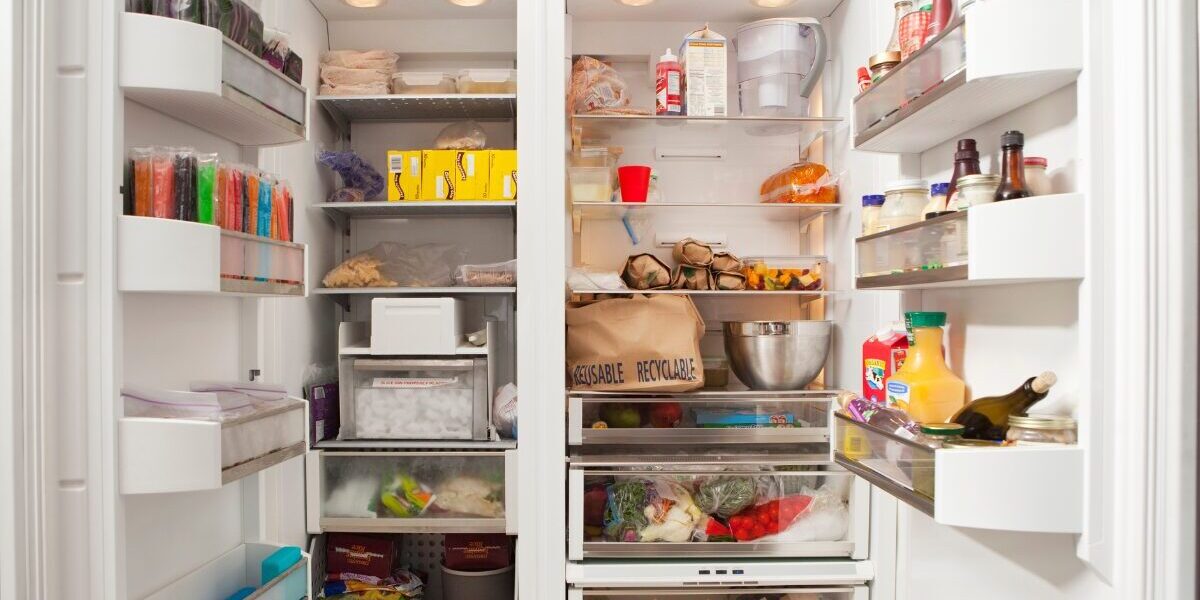 Open fridge and freezer side by side showing food inside